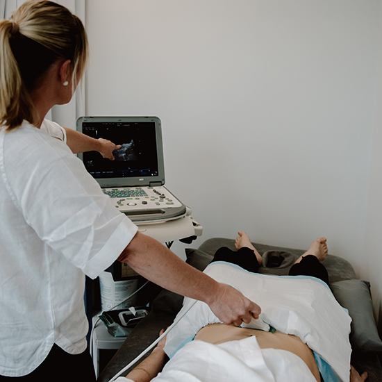 Practitioner performing pelvic ultrasound on patient